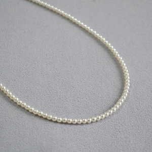 Gros plan de perles d'ivoire élégantes avec un lustre élevé sur un collier ras du cou