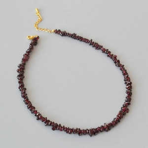 Détail d'un collier en grenat avec des pierres rouges irrégulières et un fermoir doré