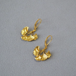 Macro view of layered ginkgo leaf earrings in vintage gold plated brass finish
