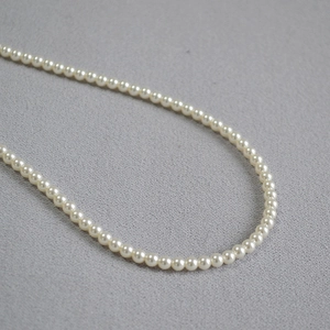 Détail macro de perles d'imitation blanc crème de 3-4mm avec un fini brillant élégant