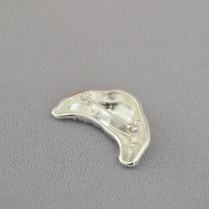 Artistic silver croissant brooch with irregular horn shape and secure pin back closure