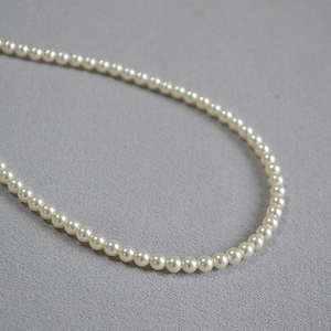 Gros plan détaillé de perles rondes de 5-7mm sur un collier élégant au fini lustré