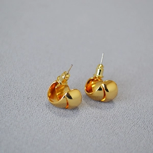 Macro shot of minimalist high-polished gold plated double C-shaped hoop earrings