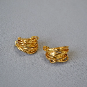 Macro detail of layered irregular gold-plated wire wrapped hoops with a high-shine finish