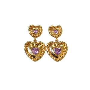 Vintage gold heart earrings with purple crystals and twisted rope texture on white backdrop