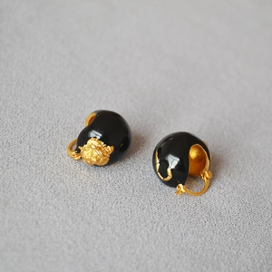 Macro detail of vintage gold lion head relief on black enamel hoop earrings for women