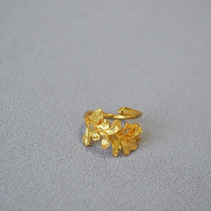 Macro detail of adjustable golden brass ginkgo leaf ring with brushed vein textures