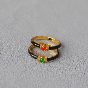 Detail of vintage gold-plated enamel rings with red and green round gemstones