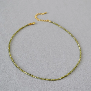 Détail du collier à perles facettées vert olive avec fermoir mousqueton doré et extension
