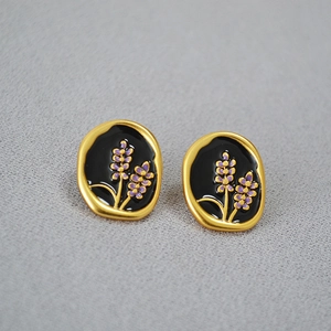 Detail of lavender enamel brass earrings with vintage gold textured borders