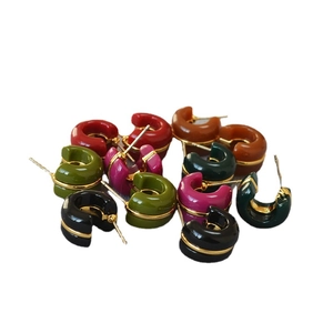 Colorful C-shape enamel hoop earrings set with gold accent lines on white background