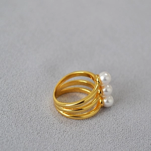 Minimalist multi-layer brass gold ring with three elegant pearls shown in a 45-degree view
