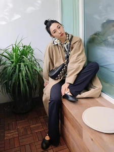 Chic black onyx stud earrings paired with a khaki trench coat and floral shirt outfit