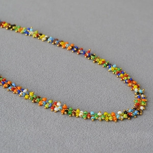 Macro shot of colorful Bohemian seed beads and gold metal spacers on a handcrafted necklace