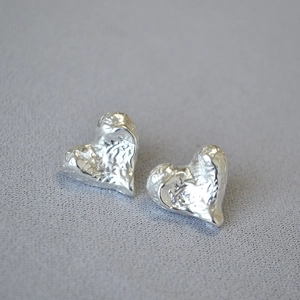 Detail shot of vintage heart studs with textured sandstone finish in silver plating