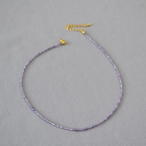 Détail du collier de perles facettées violettes avec fermoir mousqueton doré et extension