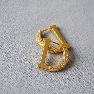 Macro shot of D-shaped gold plated earrings with micro-pave cubic zirconia crystals
