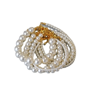 Bracelets en perles blanches élégantes avec fermoirs dorés sur un fond blanc épuré