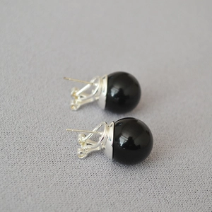 Macro shot of large black onyx bead stud earrings with polished silver metal posts
