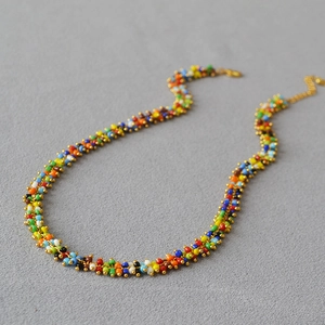 Detail of handmade colorful seed bead necklace featuring gold lobster clasp and extension chain