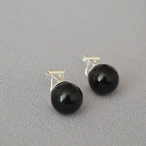 Close-up of a large black onyx spherical earring with a polished 925 silver base