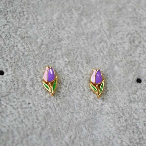 Detail of handmade enamel tulip stud earrings with pink petals and golden brass finish