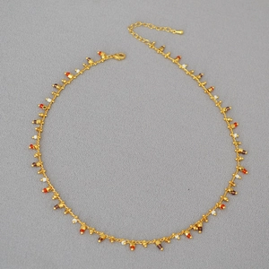 Detail of gold chain necklace with colorful beads, lobster clasp and extension chain