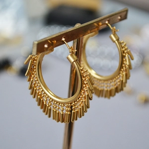 Detailed macro view of vintage gold plated brass earrings featuring long dynamic tassels