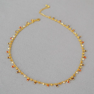 Detail of gold chain necklace with colorful beads, lobster clasp and extender