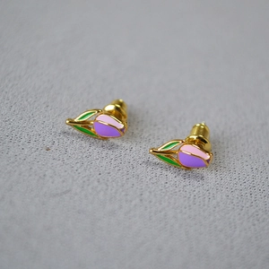 Handmade gold plated tulip stud earrings with purple and pink enamel on grey surface