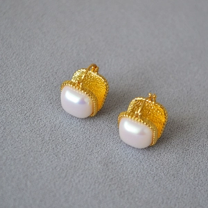 Détail de boucles d'oreilles en laiton doré avec perles baroques carrées et texture martelée