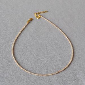 Détail du collier de perles facettées champagne avec fermoir mousqueton doré