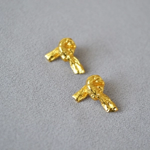 Vue détaillée de boucles d'oreilles nœud en laiton doré avec texture martelée