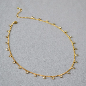 Detail of gold plated brass necklace with sparkling crystal charms and lobster clasp
