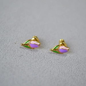 Macro shot of tulip stud earrings with pink enamel petals and gold butterfly clasp