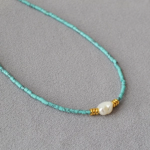 Handmade turquoise beaded necklace featuring a white baroque pearl and golden accents