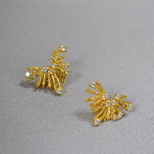 Dettaglio degli orecchini a lobo a ramo dorato con brillanti cristalli di zircone