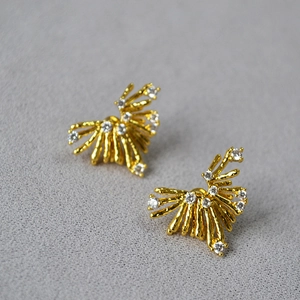 Dettaglio di orecchini d'oro con cristalli di zircone e perni in argento 925 puro