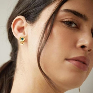 Detailed close-up of vintage geometric gold earrings with peacock blue enamel accents