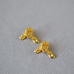 Vue détaillée de boucles d'oreilles nœuds dorés avec une texture vintage martelée