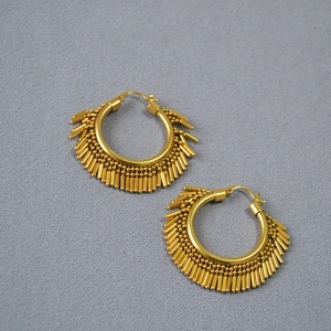 Detailed view of vintage gold-plated brass hoop earrings with dynamic fringe tassels