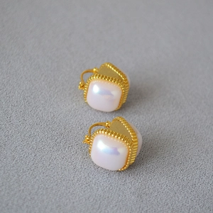 Détail de boucles d'oreilles carrées en perles Mabe avec bords perlés en laiton doré vintage