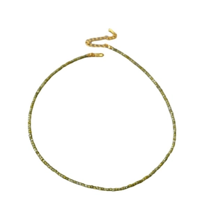 Collier de perles de zircon vert avec chaîne d'extension dorée sur fond blanc