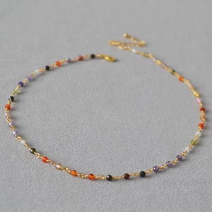 Detailed macro of gold plated chain necklace with multi-colored faceted zircon beads