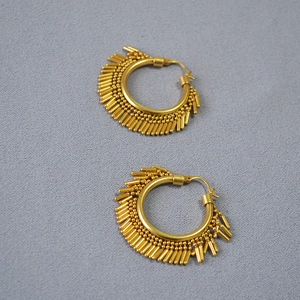 Detailed view of gold plated brass hoop earrings featuring dynamic vertical fringe tassels