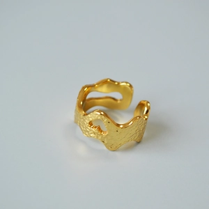 Macro view of gold plated wide ring with hammered texture and heart cutout design