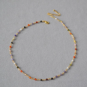 Detailed close-up of colorful faceted zircon beads on a minimalist gold-plated brass chain