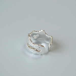 Macro detail of silver adjustable ring featuring irregular hammered texture and heart cutout
