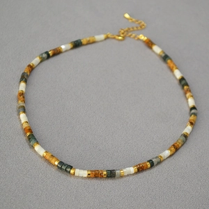 Détail du collier de perles avec pierres colorées, entretoises dorées et fermoir