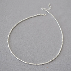 Vue détaillée du collier de perles argentées avec fermoir mousqueton et chaînette